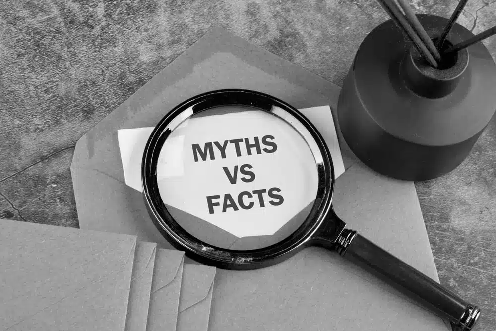 Magnifying glass over a sheet that reads MYTHS VS FACTS on a desk