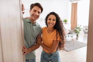 Casal sorridente entrando em sua nova casa depois de aprender os passos para comprar uma casa na Flórida.