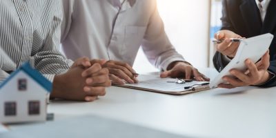 HappyCoupleSigningAContractWithRealEstateAgentRenters